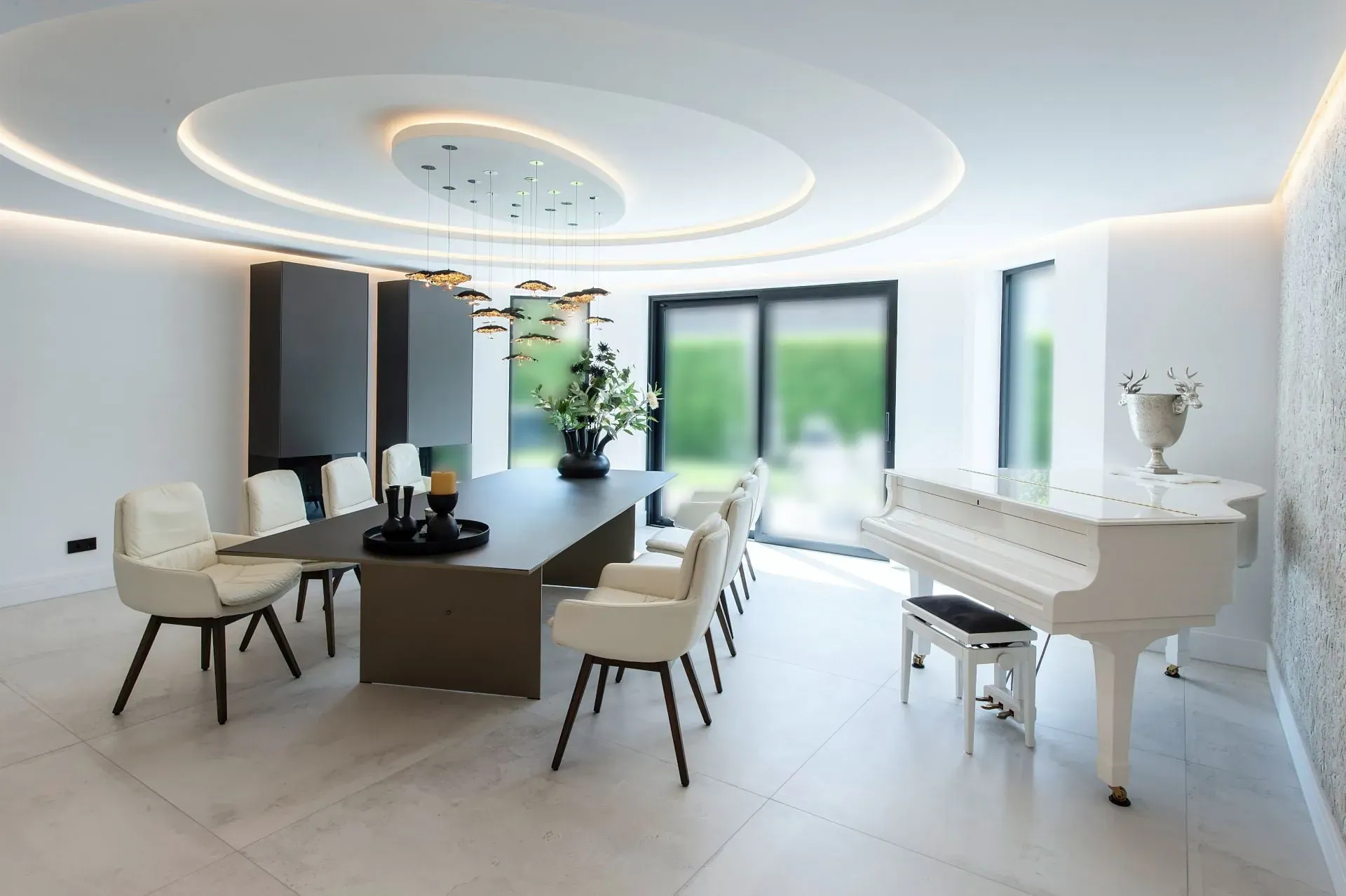 Modernes Esszimmer mit ovaler Lichtdecke und weißem Konzertflügel